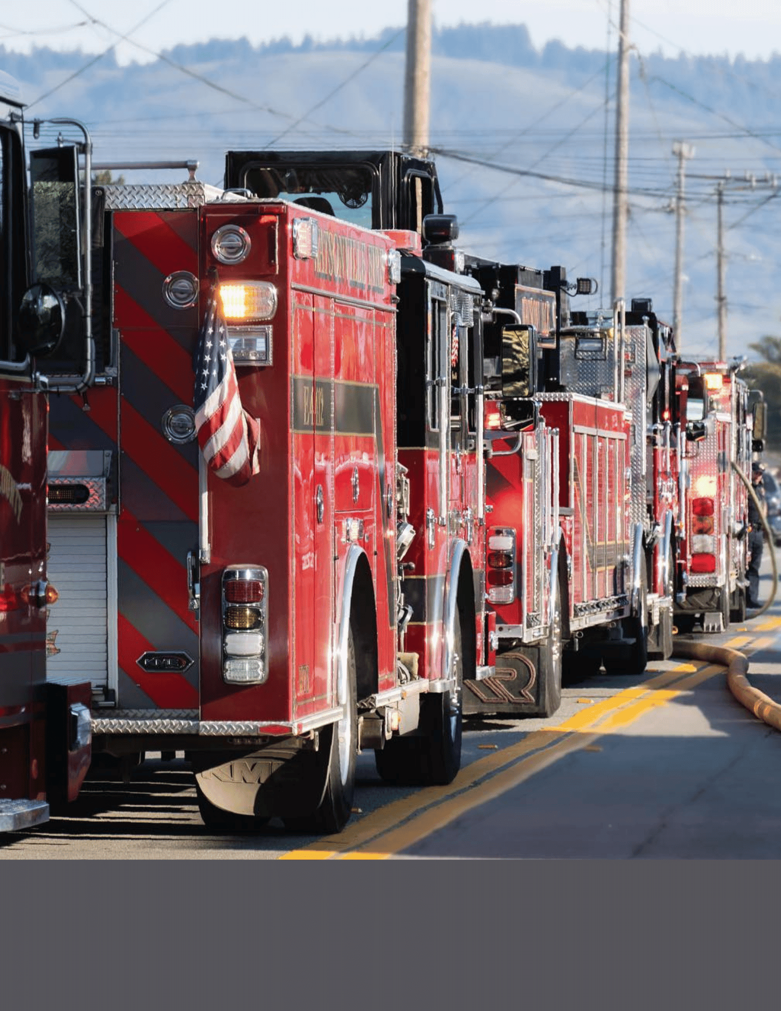 Several fire engines lined up on a street during an incident 