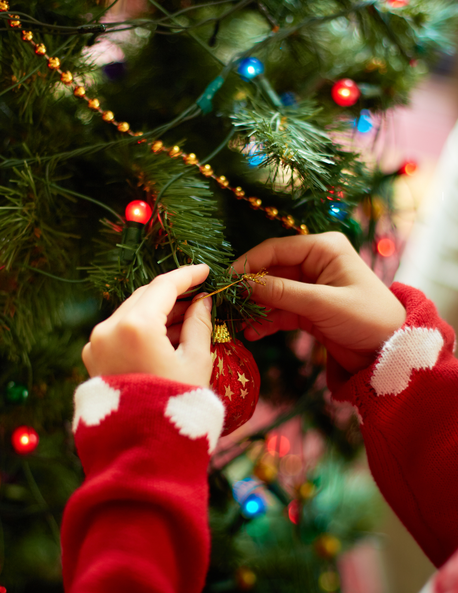 Photo of hands removing ornaments from a Christmas tree