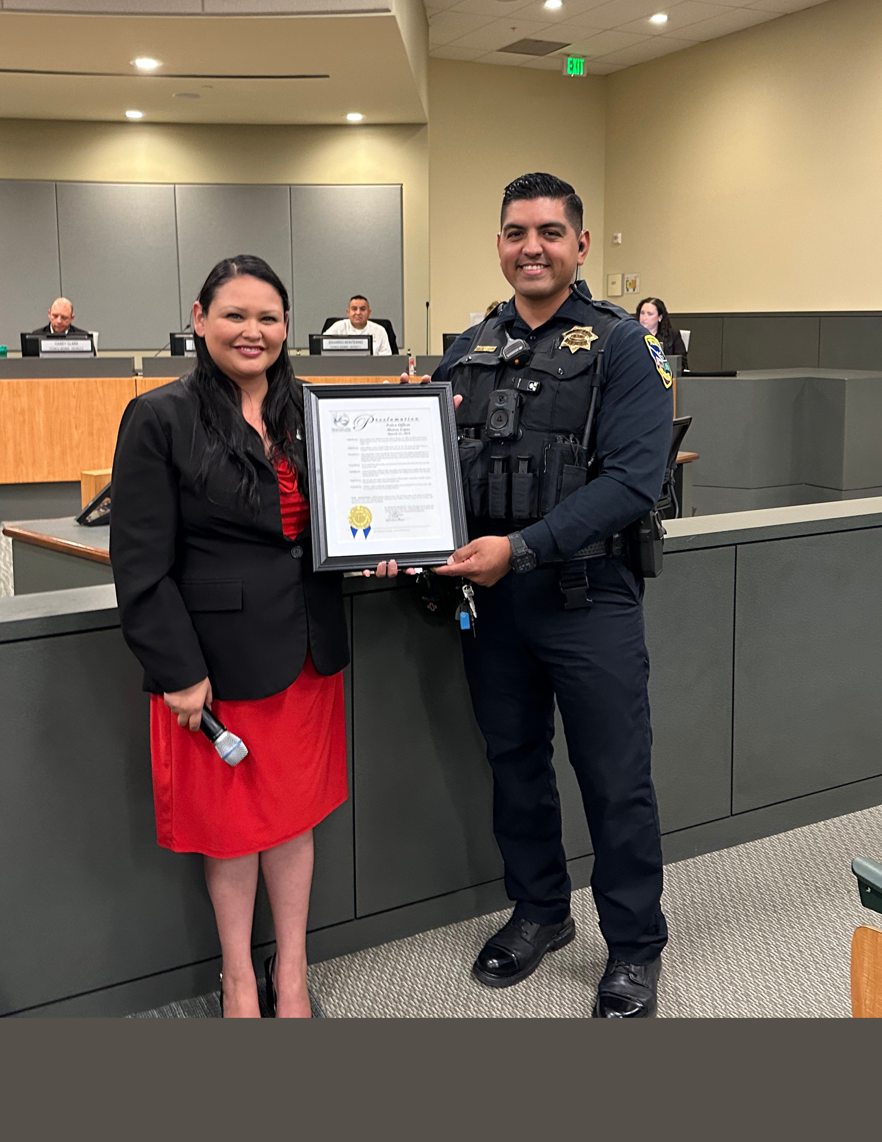 Ofc. M. Lopez and Mayor Orozco holding a proclamation that Officer Lopez received 