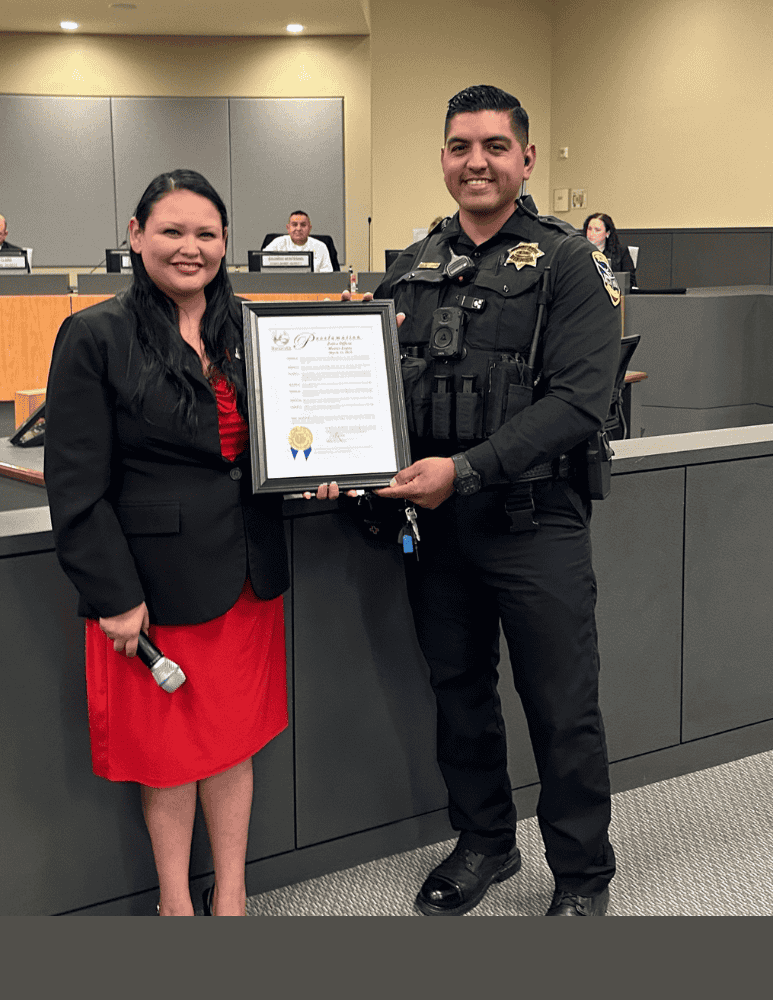 Ofc. M. Lopez and Mayor Orozco holding a proclamation that Officer Lopez received 