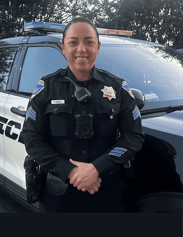 Sgt Monique standing next to a patrol car 