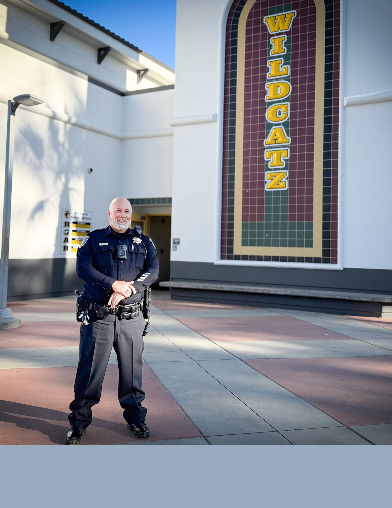 Photo of New School Resource Officer Rosas standing outside the Gym at Watsonville High School 