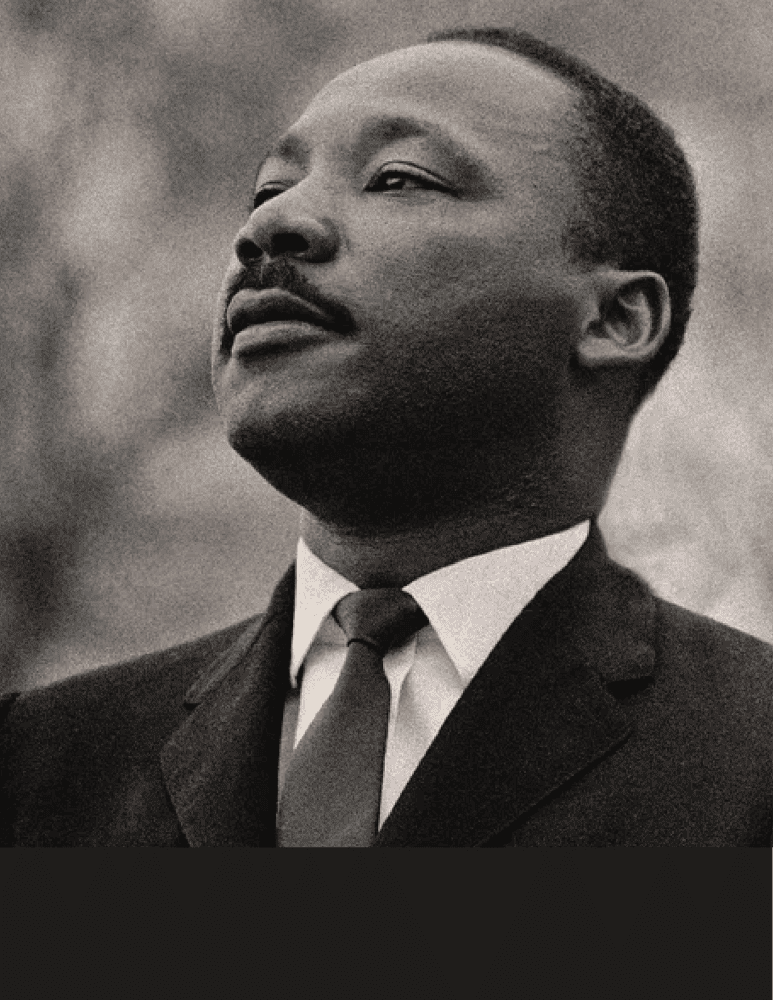 Black-and-white portrait of Dr. Martin Luther King Jr. in a suit, looking upward