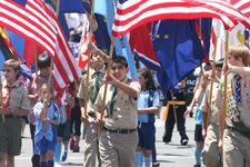 Boy Scouts holding flags walking in a parade