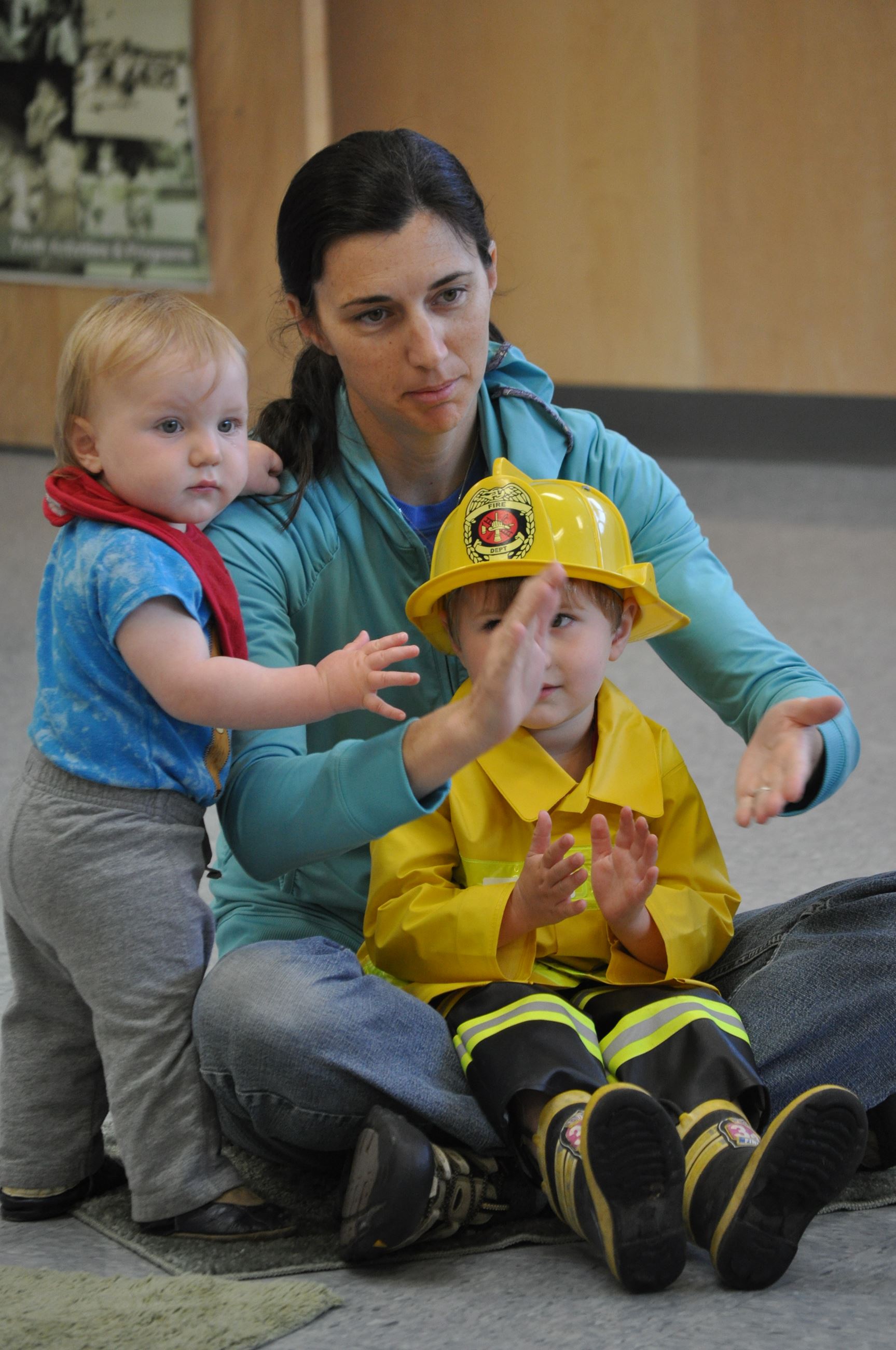 Mother sitting with her two young children clapping