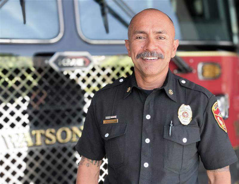 Headshot of Chief Lopez standing in front of fire truck 