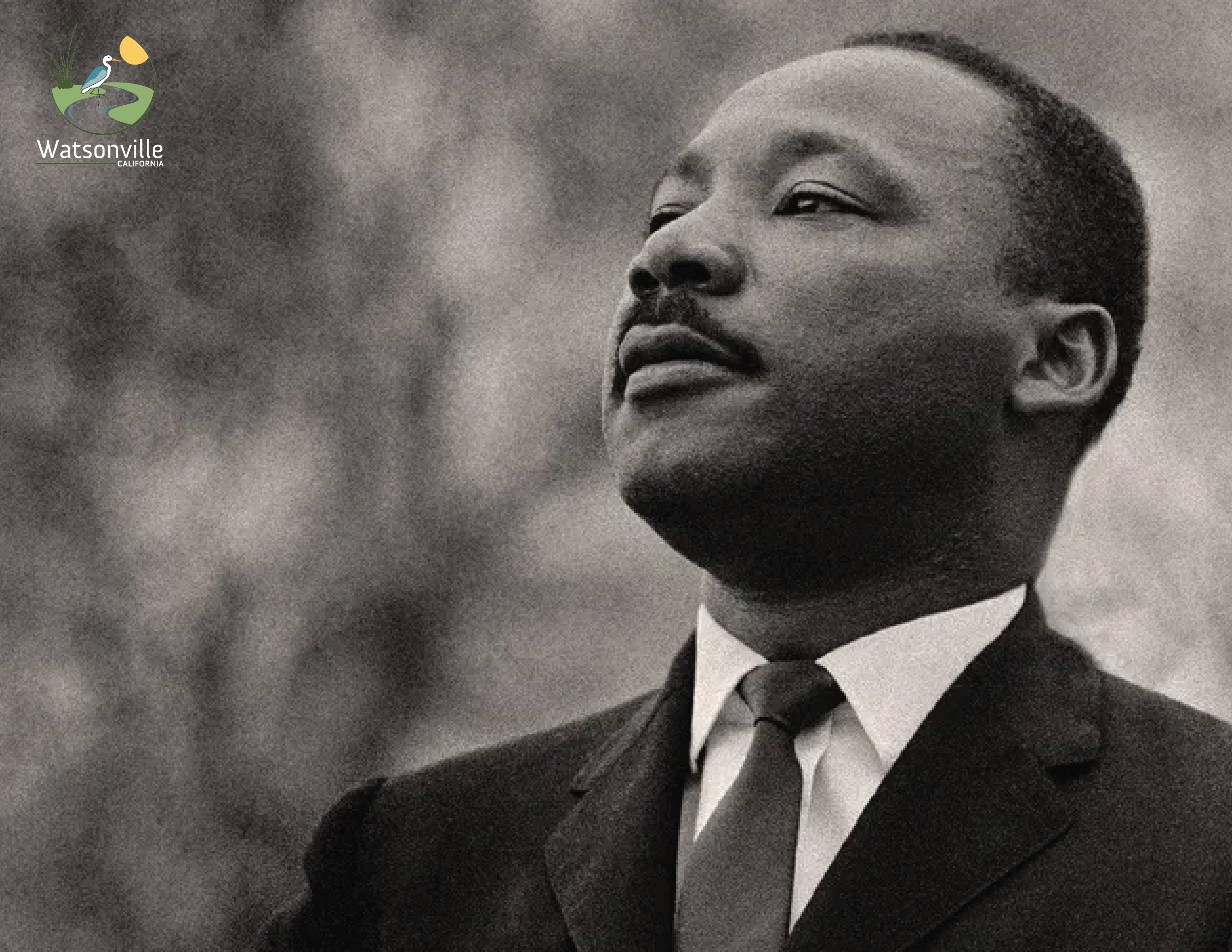 Black-and-white portrait of Dr. Martin Luther King Jr. in a suit, looking upward