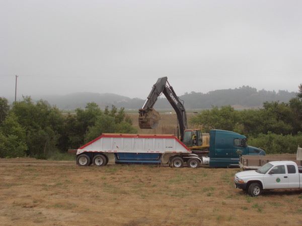 Construction Equipment Dumping Dirt in Dump Truck