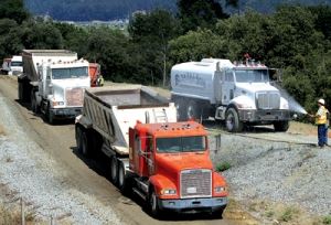 Several Dump Trucks Driving One by One
