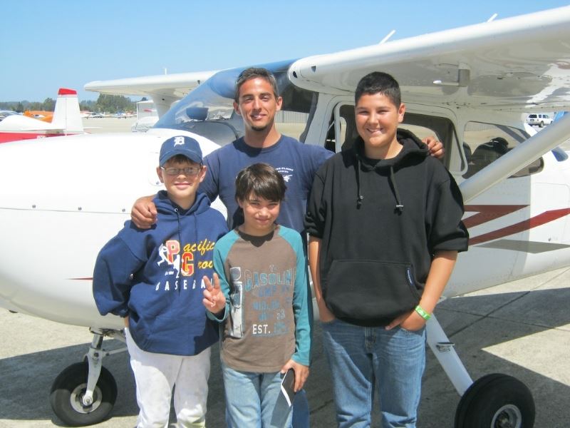 Kids Standing in Front of Airplane